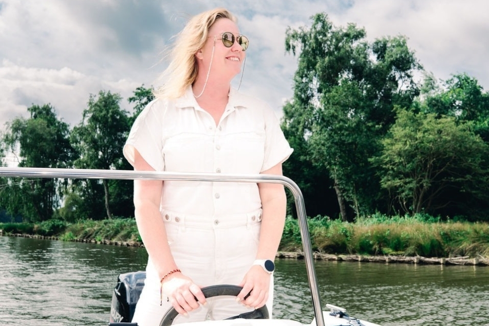 Maaike Bloupot aan het stuur op de boot van haar ouders